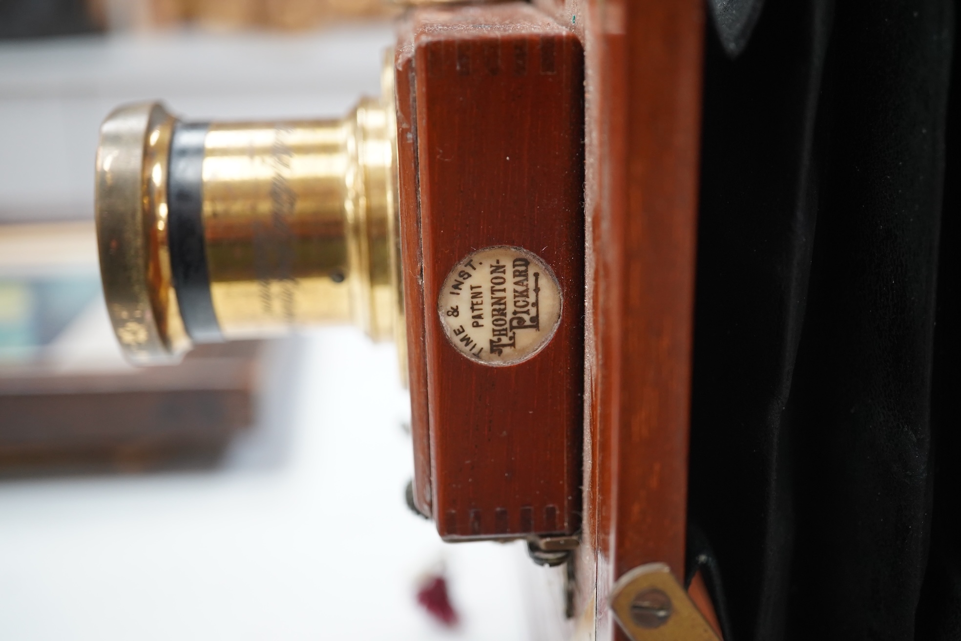 A late 19th/early 20th century brass and mahogany half plate bellows camera with a lens and a shutter action by Thornton Pickard. Condition - glass missing